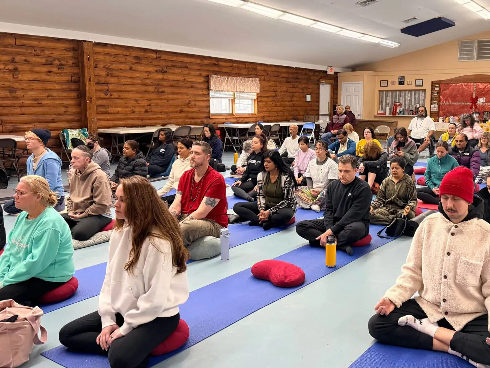 Meditators on cushions and mats in the hall at Middlesex County 4-H Center, East Brunswick NJ